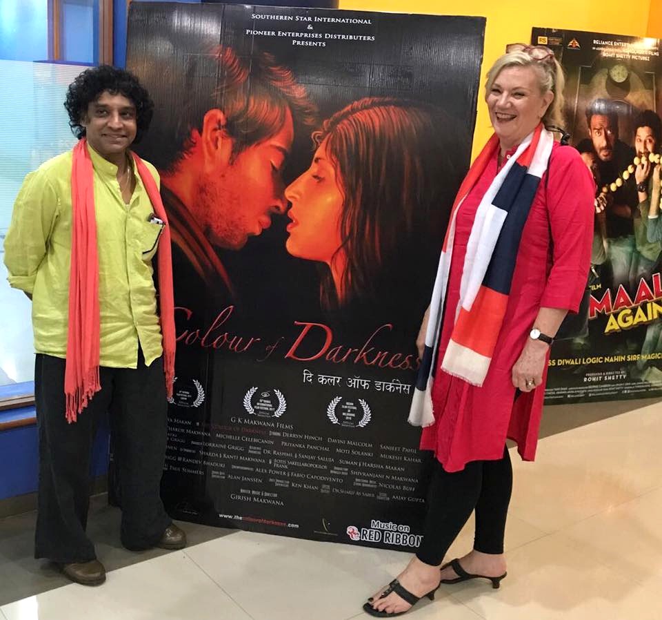 Girish Makwana and Lorraine Grigg beside The Colour of Darkness poster